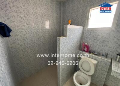 Spacious bathroom with modern tiles and essential fixtures