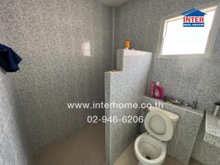 Spacious bathroom with modern tiles and essential fixtures