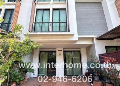 Modern three-story townhouse with balcony and garden front