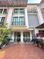 Modern three-story townhouse with balcony and garden front