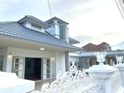 Elegant residential home with a tiled roof and spacious porch