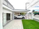 Modern house exterior with carport and landscaped lawn