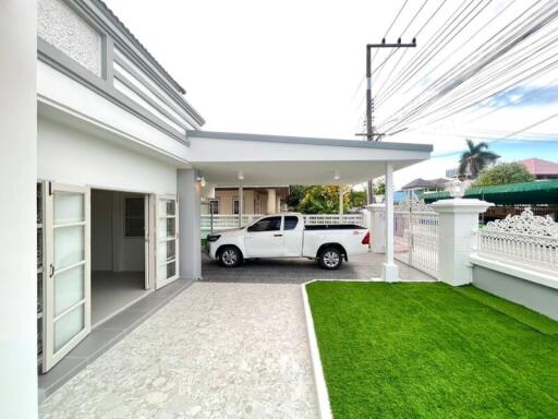 Modern house exterior with carport and landscaped lawn