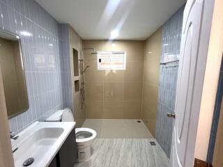 Spacious modern bathroom with light blue tiles