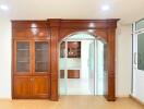 Elegant archway leading from a wooden furnished living room to a modern kitchen