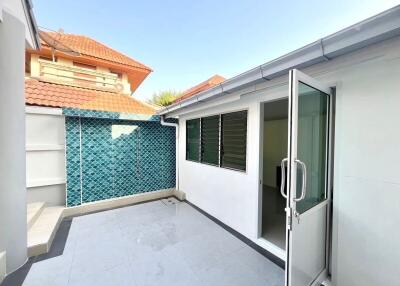 Spacious tiled patio with a glass door and blue mosaic tile wall