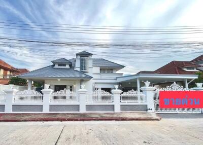 Elegant two-story residential home with white fencing