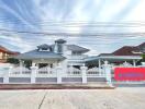 Elegant two-story residential home with white fencing