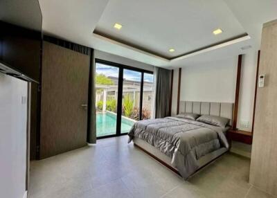Modern bedroom with direct pool access through sliding glass doors