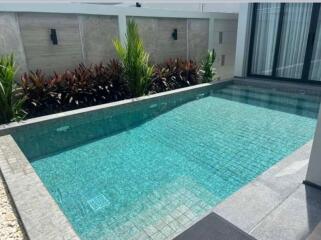 Elegant outdoor swimming pool with clear blue water and surrounding garden