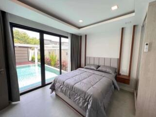 Modern bedroom with pool view through large windows