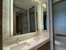 Modern bathroom interior with elegant marble finish and well-lit mirrors