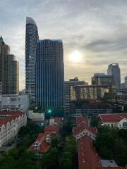 Modern city skyline with tall buildings and sunset