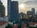 Modern city skyline with tall buildings and sunset