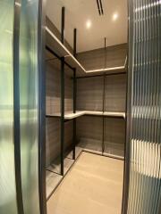 Modern walk-in closet with shelves and stylish lighting