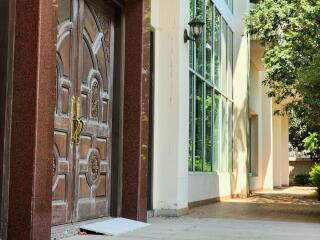 Elegant exterior view of a building showcasing a vintage wooden door and modern glass windows