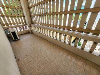 Spacious balcony with tiled flooring and latticed privacy screens