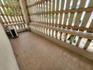 Spacious balcony with tiled flooring and latticed privacy screens