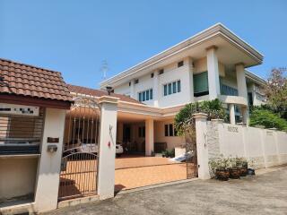 Spacious white two-story house with a tile roof and attached garage