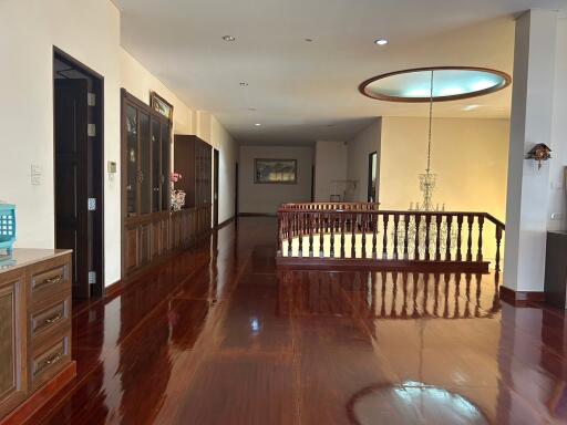 Spacious hallway with polished wooden floors and elegant lighting