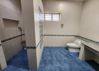 Spacious bathroom with white tiles and blue flooring