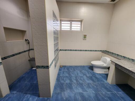 Spacious bathroom with white tiles and blue flooring