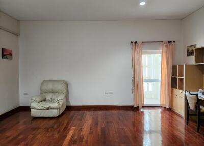 Spacious and bright living room with hardwood floors, minimal furnishings, and balcony access