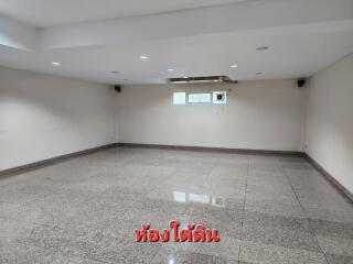 Spacious empty room with tiled flooring and high ceiling