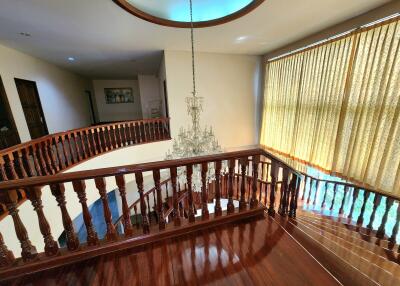 Elegant hallway with wooden railing and a grand chandelier