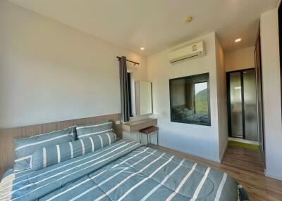 Spacious bedroom with modern design, scenic view, and ample lighting