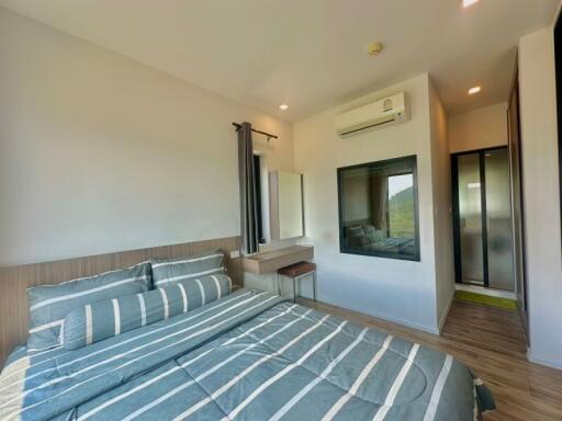 Spacious bedroom with modern design, scenic view, and ample lighting