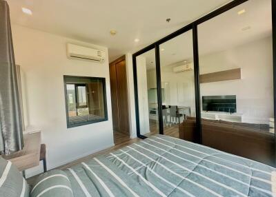 Modern bedroom with direct view into living space through large glass doors