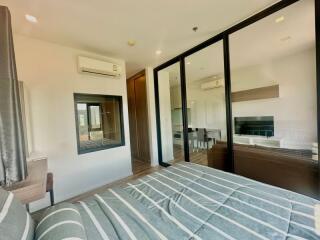 Modern bedroom with direct view into living space through large glass doors