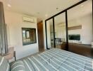 Modern bedroom with direct view into living space through large glass doors