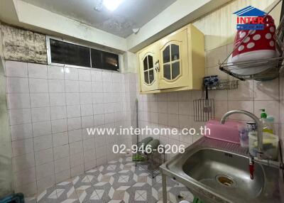 Old style kitchen with tiled walls and basic appliances