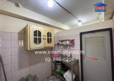 Compact kitchen with white tiling and wooden cabinets