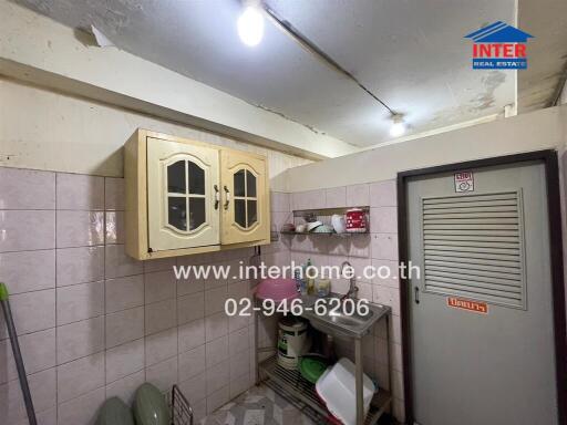 Compact kitchen with white tiling and wooden cabinets