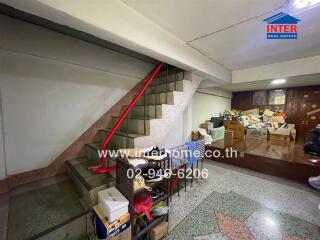 cluttered storage space under staircase in a building