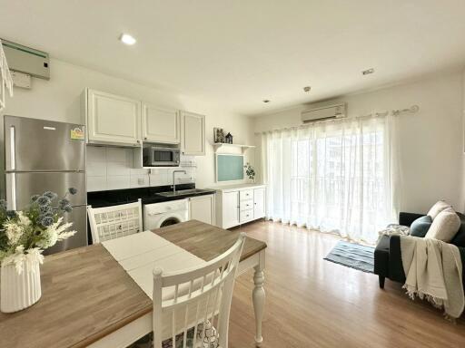 Spacious combined kitchen and living area with modern appliances and ample natural light