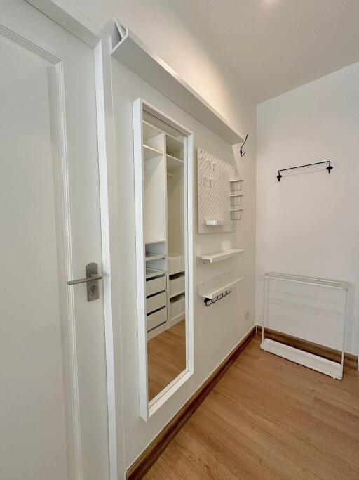 Bright and modern hallway with open closet and wooden flooring