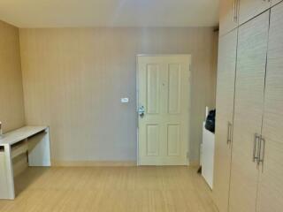 Minimalist bedroom with ample storage and light wood flooring