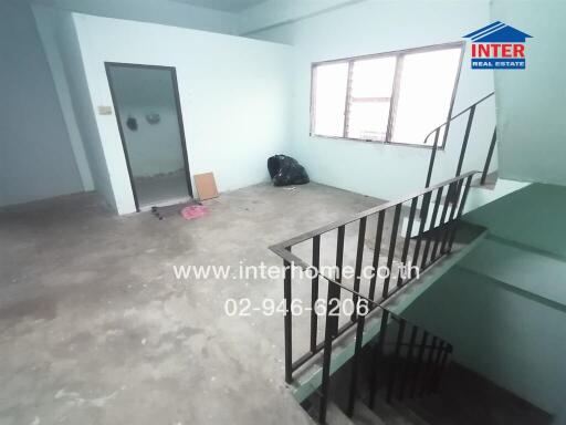 Spacious empty room with staircase and large window