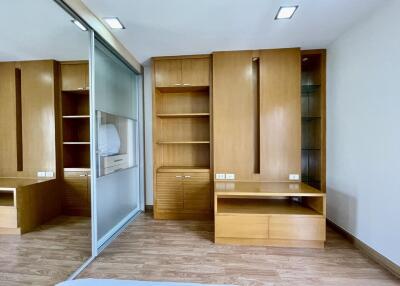 Spacious bedroom with built-in wooden wardrobes and ample storage