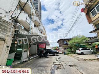 Street view of building with parking and vehicles