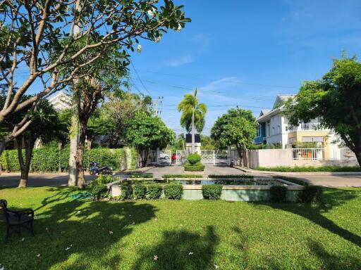 Spacious and well-maintained front yard of a residential property with lush green grass and mature trees