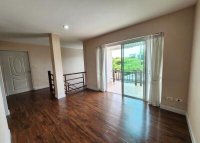 Spacious living room with hardwood floors and large sliding glass doors leading to a balcony