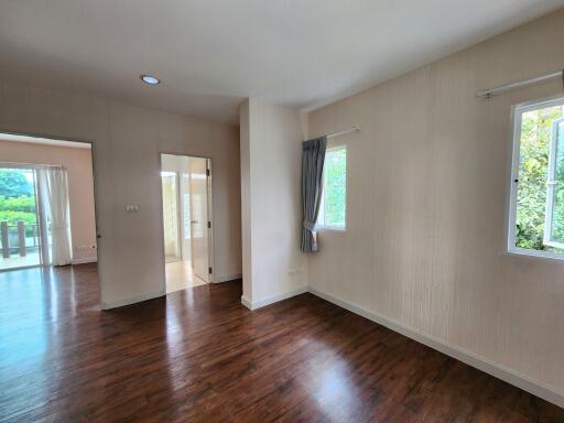 Spacious unfurnished living room with wooden flooring and good natural light