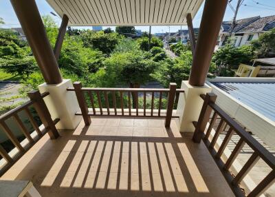 Spacious balcony with scenic garden view and wooden railing
