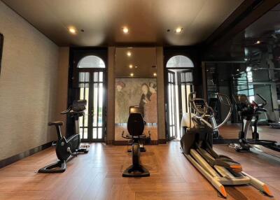 Modern home gym with various exercise equipment and hardwood floors