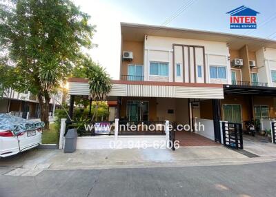 Modern two-story townhouse with landscaped front yard and private parking